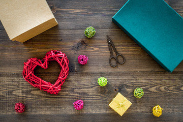 Packaging gift. Colored gift boxes, sciccors, thin cord on dark wooden background top view