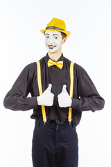 Portrait of a male, pantomime actor looking at camera and showing thumb up.