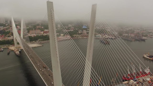 Amazing zooming out aerial view of the Zolotoy Bridge (the Golden Bridge) that is cable-stayed bridge across the Zolotoy Rog built in 2012 in Vladivostok, Russia, and cars driving on it. 4k