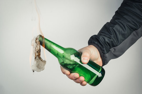 Glass bottle, the so-called Molotov cocktail in the hand of the activist. Isolated on a white background.
