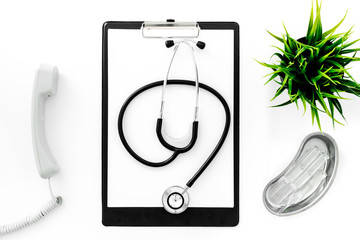 Fototapeta premium Call doctor. Phone, clip pad, stethoscope and cuvette with ampoulie on white background top view