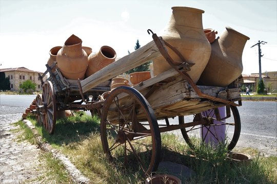 An old wooden wagon loaded with old ceramic clay pots 