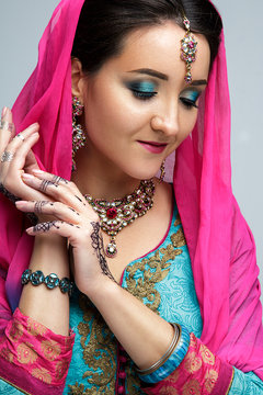 Portrait of beautiful smiling indian girl. Young indian woman model with traditional jewelry set . Indian costume saree