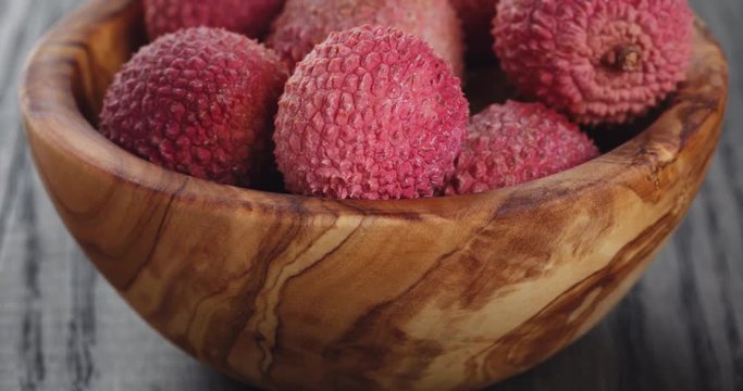 ripe lychees in wood bowl
