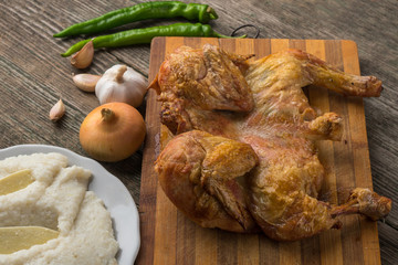 Fried chicken, ghomi and vegetables on an old wooden board, Georgia, Samegrelo