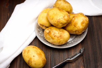 Raw potatoes on a brown wooden background
