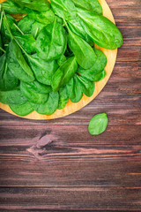 Fresh juicy spinach leaves on a wooden brown table. Natural products, greens, healthy food, vitamins.
