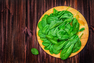 Fresh juicy spinach leaves on a wooden brown table. Natural products, greens, healthy food,...