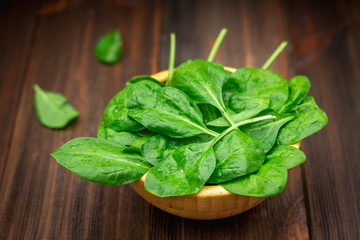 Fresh juicy spinach leaves on a wooden brown table. Natural products, greens, healthy food, vitamins.