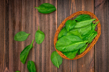 Fresh juicy spinach leaves on a wooden brown table. Natural products, greens, healthy food, vitamins.