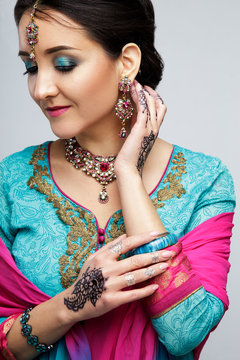 Portrait of beautiful smiling indian girl. Young indian woman model with traditional jewelry set . Indian costume saree