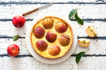 Apple pie with whole red apples and cream