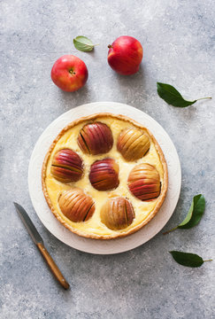 Apple pie with whole red apples and cream