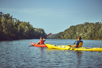 A canoe trip along the river along the forest in summer.