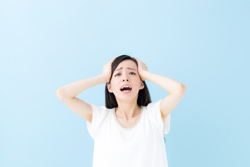 頭を抱える女性・ブルーバック
