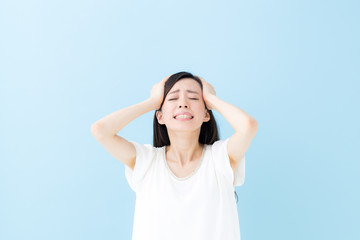 頭を抱える女性・ブルーバック