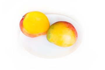 Fresh ripe mango on a platter, shown on a light background
