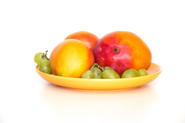 Fresh mango shown on the plate and light background.