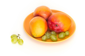 Fresh mango shown on the plate and light background.