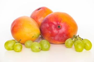 Fresh ripe mango, shown on a light background with grape balls