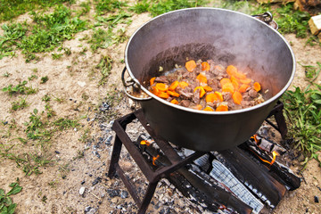 raditional cooking in the nature. Cauldron on fire