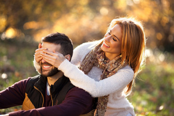 Love couple sitting under a tree in the colorful spring garden at sunset