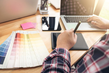 Architectural drawing with work tools, Graphic designer working with digital Drawing tablet and Pen on a computer and color swatches on a desk, interactive pen display, sketching at blank notepad,