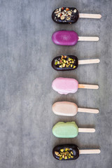 Flat lay with colorful popsicles on white marble table. Summer ice cream pattern