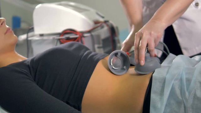 A nurse applies and pushes electrodes on a patient.