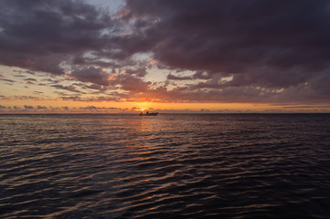 Sonnenuntergang am Strand mit der Sonne über dem Meer