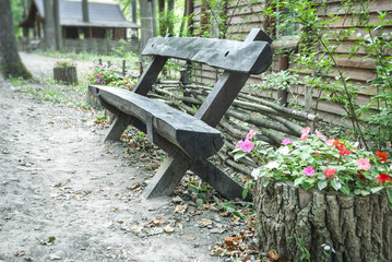 Naklejka premium Old rustic wood bench by a walking path