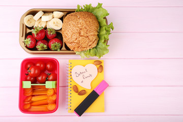 School lunch in boxes on pink wooden table