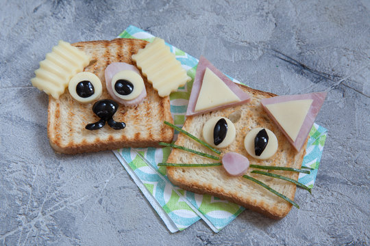 Funny dog and cat sandwich for kids lunch on a table.