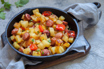 Fried potatoes with red peppers and sausages