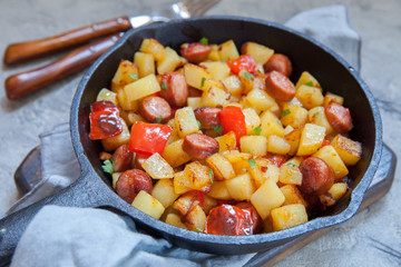 Fried potatoes with red peppers and sausages