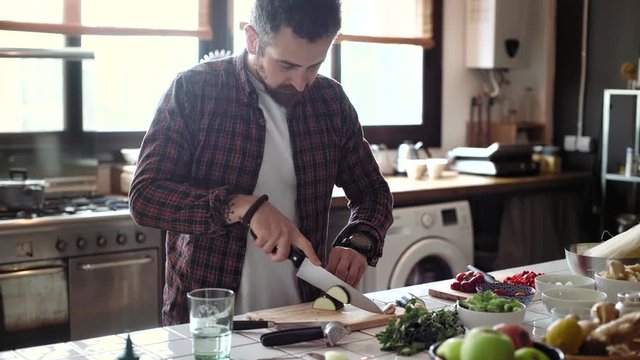 Handsome young man in checked shirt prepares healthy breakfast snack for his beautiful wife girlfriend lover in modern designed kitchen on sunny lazy weekend