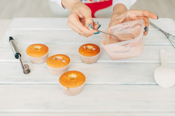 Young girl makes delicious tender cupcakes.