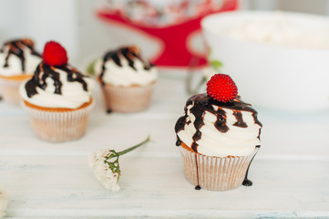 Delicate tasty muffins decorated with raspberries and poured wit