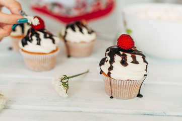 Delicate tasty muffins decorated with raspberries and poured wit