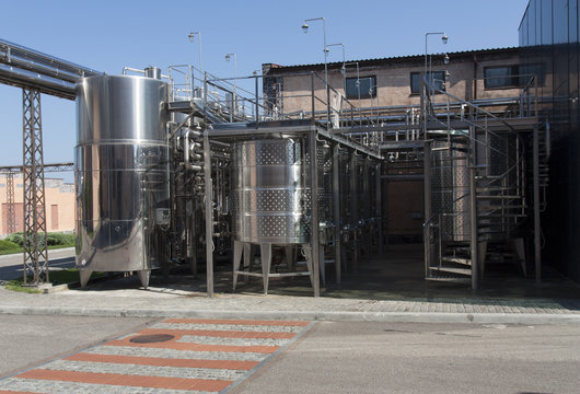 Metal chrome cask for wine photo. Stainless steel pipes and barrels as part of winery equipment