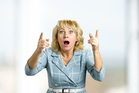 Surprise Astonished Mature Woman. Close Up Portrait Of Middle Aged Woman Looking Surprised And Having An Idea With Wide Open Mouth And Raised Hands.