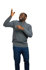 Happy black man showing direction. Man with raised right arm smile on white background.