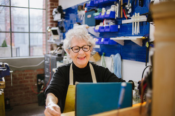 Art Jeweler on tablet computer in studio