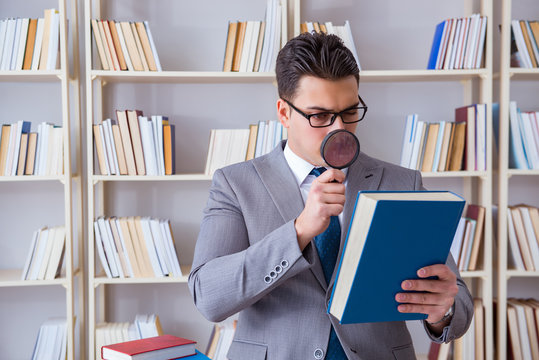 Business Law Student With Magnifying Glass Reading A Book