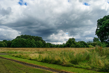 Fototapeta na wymiar Railroad and heavy clouds. Countryside landscape.