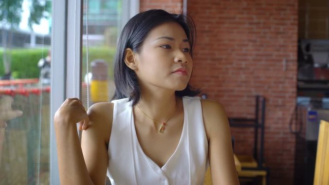 Beautiful young Asian Lady waiting for her order at cafe 4k UHD (3840x2160)
