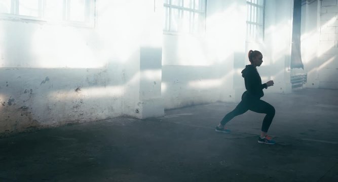 WIDE Caucasian female in sport outfit stretching before martial arts training. 4K UHD, 60 FPS SLO MO