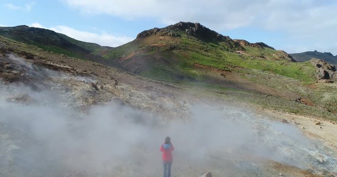 Iceland tourist near volcano geothermal field with volcanic activity fumaroles taking pictures in Seltun geothermal field in Krysuvik, Reykjanes peninsula. Iceland photographer