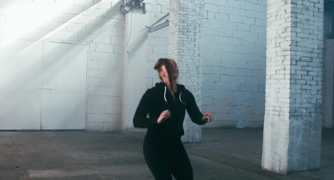 MED Caucasian female in sport outfit stretching before martial arts training. 4K UHD, 60 FPS SLO MO