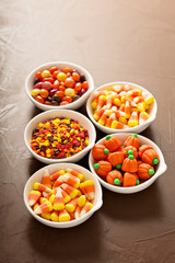 Halloween candy and sprinkles in white bowls